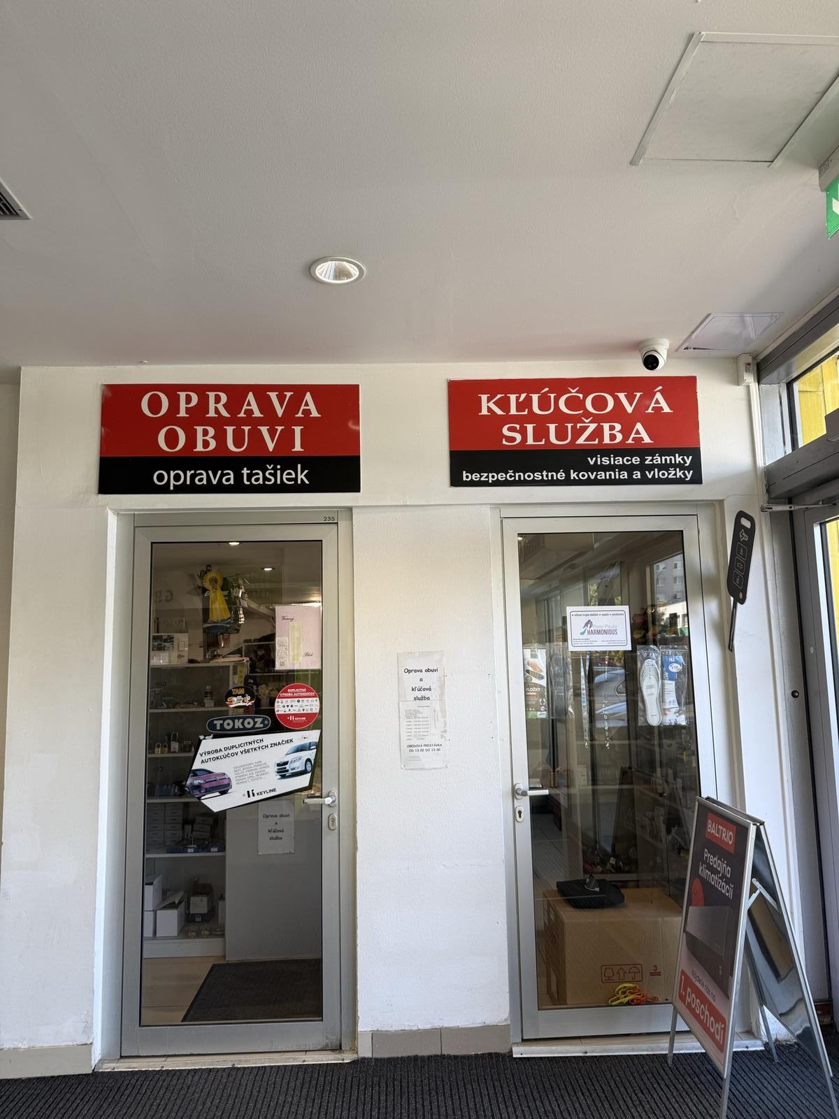 Vchod do prevádzky v OD Saratov s tabuľami Oprava obuvi a Kľúčová služba